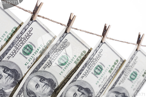 Image of Hundred Dollar Bills Hanging From Clothesline on White