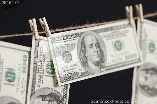 Image of Hundred Dollar Bills Hanging From Clothesline on Dark Background