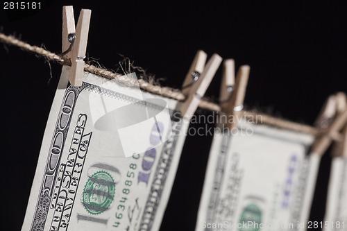 Image of Hundred Dollar Bills Hanging From Clothesline on Dark Background