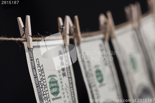 Image of Hundred Dollar Bills Hanging From Clothesline on Dark Background