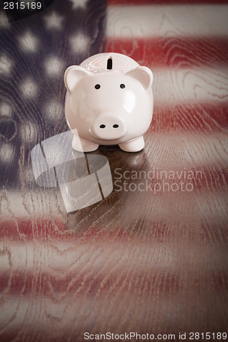 Image of Piggy Bank with an American Flag Reflection on Table