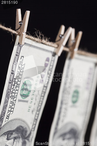 Image of Hundred Dollar Bills Hanging From Clothesline on Dark Background