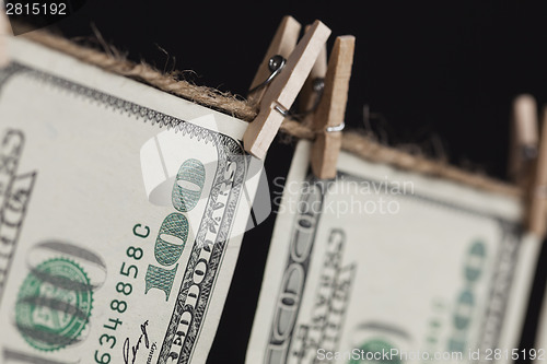 Image of Hundred Dollar Bills Hanging From Clothesline on Dark Background