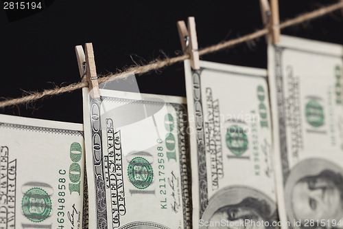 Image of Hundred Dollar Bills Hanging From Clothesline on Dark Background