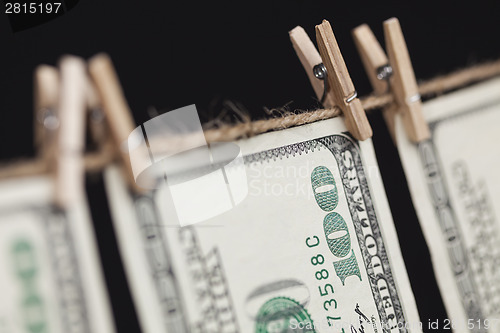 Image of Hundred Dollar Bills Hanging From Clothesline on Dark Background