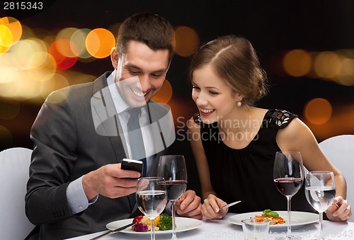 Image of smiling couple eating main course at restaurant