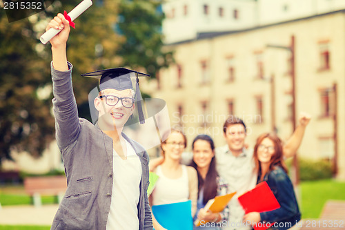 Image of smiling teenage boy in corner-cap with diploma