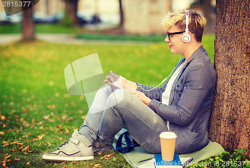 Image of boy with headphones, tablet pc, books and coffee