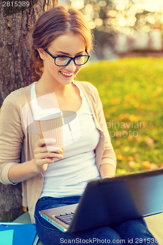 Image of teenager in eyeglasses with laptop and coffee