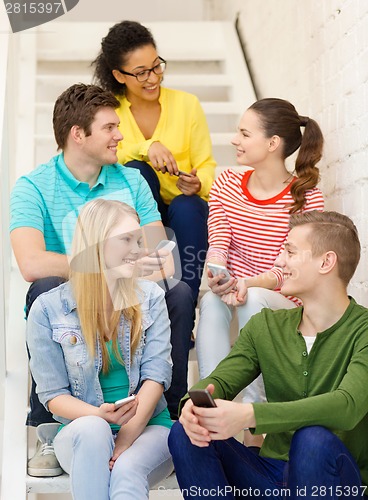 Image of smiling students with smartphone having discussion