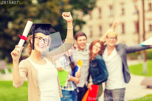 Image of smiling teenage girl in corner-cap with diploma