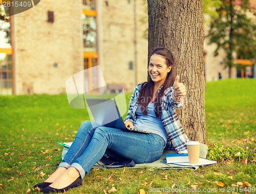 Image of teenager with laptop and coffee showing thumbs up