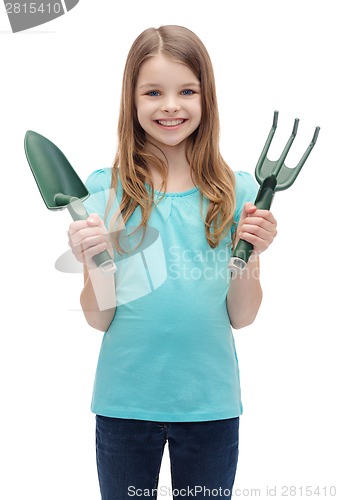 Image of smiling little girl with rake and scoop