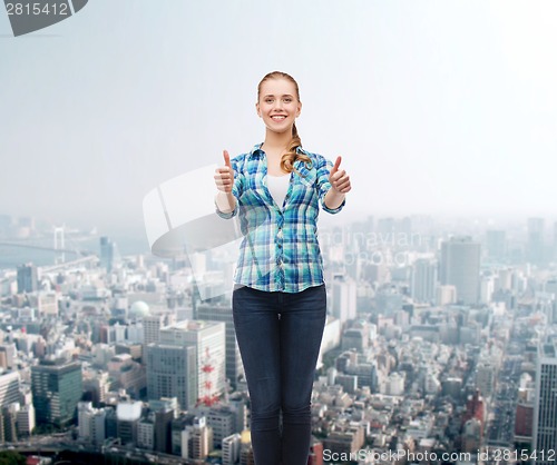 Image of young woman in casual clothes showing thumbs up