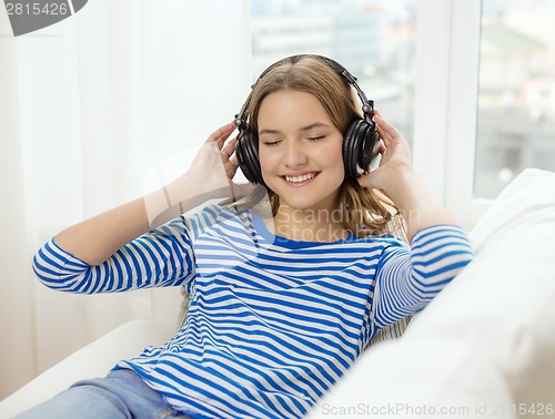 Image of smiling young girl in headphones at home