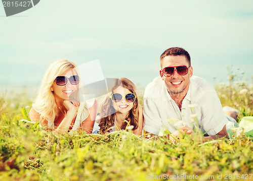 Image of happy family with blue sky and green grass