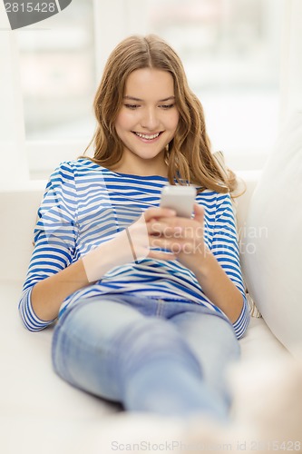 Image of smiling teenage girl with smartphone at home