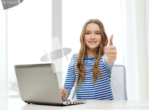 Image of smiling teenage gitl with laptop computer at home