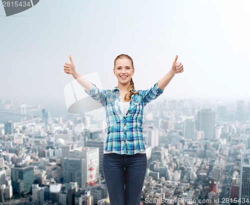 Image of smiling girl in casual clothes showing thumbs up