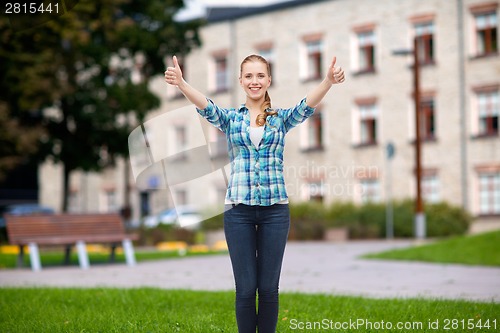 Image of smiling girl in casual clothes showing thumbs up