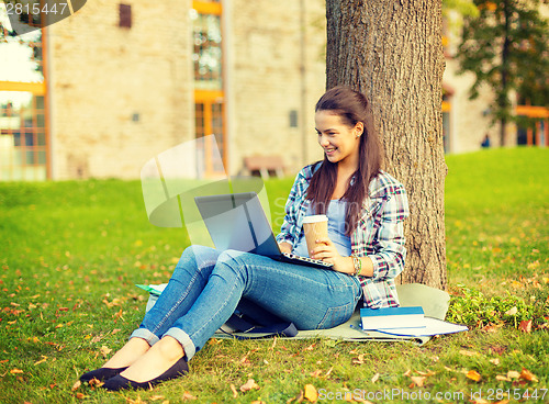 Image of teenager in eyeglasses with laptop and coffee