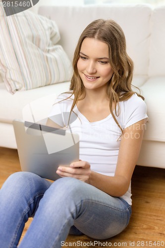 Image of smiling teenage girl with tablet pc at home