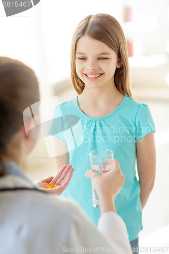 Image of female doctor giving pills and water to child
