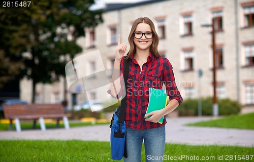 Image of smiling female student with bag and notebooks