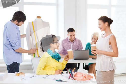 Image of smiling fashion designers working in office