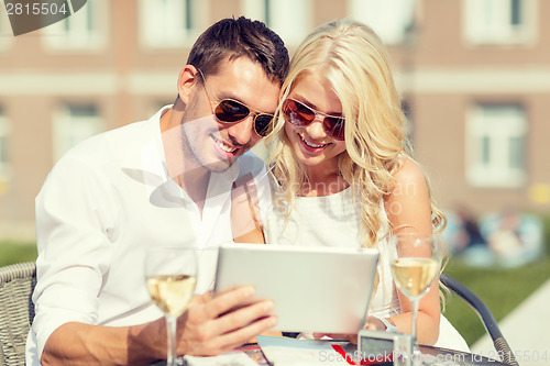 Image of couple looking at tablet pc in cafe