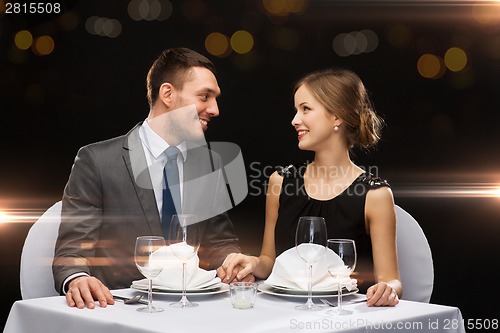 Image of smiling couple looking at each other at restaurant