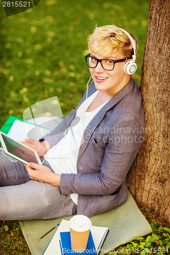 Image of boy with headphones, tablet pc, books and coffee