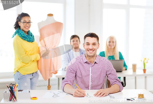 Image of smiling fashion designers working in office