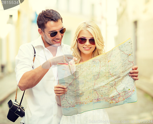 Image of smiling couple in sunglasses with map in the city