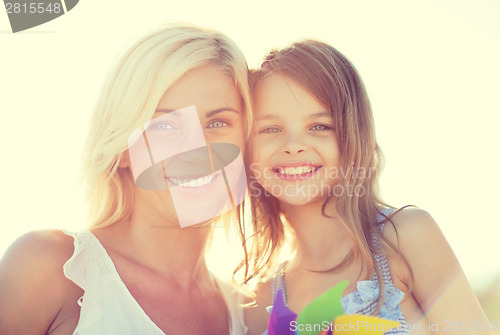 Image of happy mother and child girl with pinwheel toy