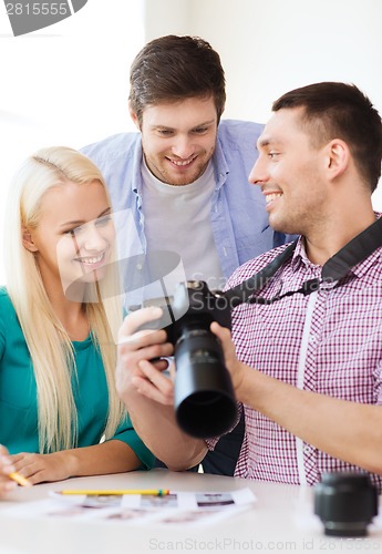 Image of smiling team with photocamera working in office