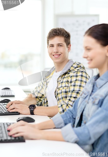 Image of smiling boy with girl in computer class at school