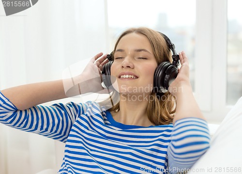 Image of smiling young girl in headphones at home