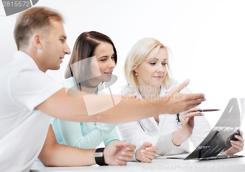 Image of doctor with patients looking at x-ray