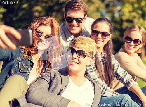 Image of teenagers taking photo with smartphone outside