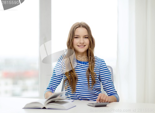 Image of student girl with book, calculator and notebook