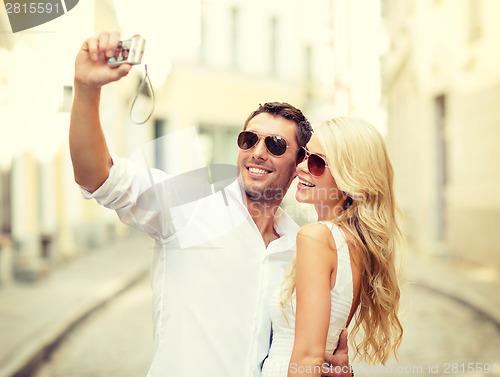 Image of travelling couple taking photo picture with camera