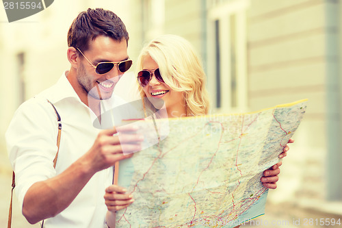 Image of smiling couple in sunglasses with map in the city