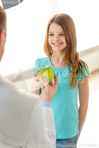 Image of male doctor giving an apple to smiling little girl