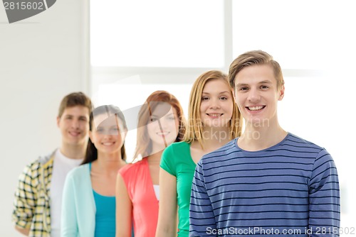 Image of smiling students with teenage boy in front