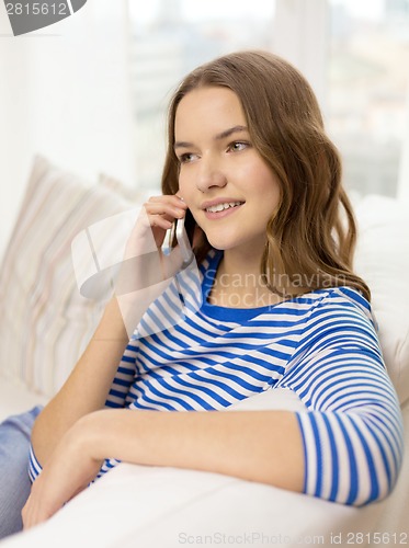 Image of smiling teenage girl with smartphone at home