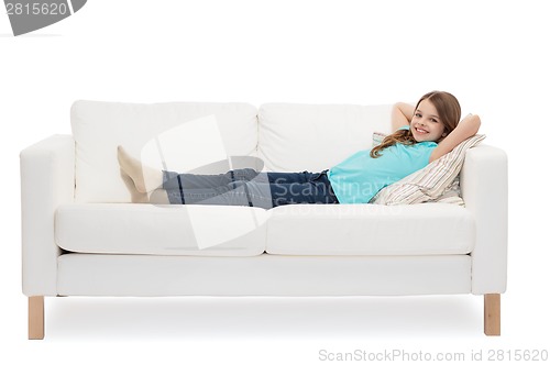 Image of smiling little girl lying on sofa