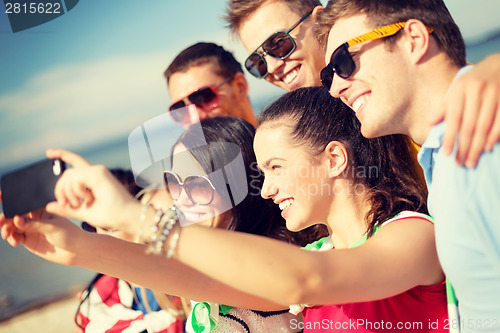 Image of group of friends taking picture with smartphone