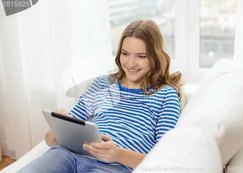 Image of smiling teenage girl with tablet pc at home