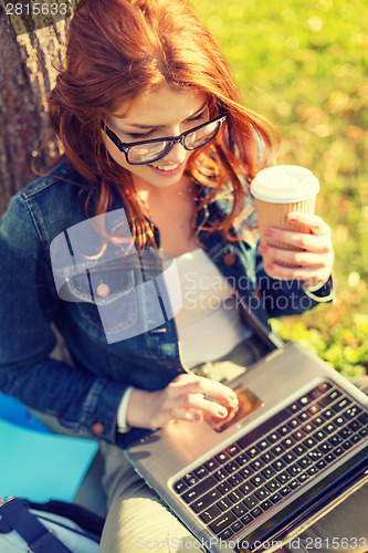 Image of teenager in eyeglasses with laptop and coffee